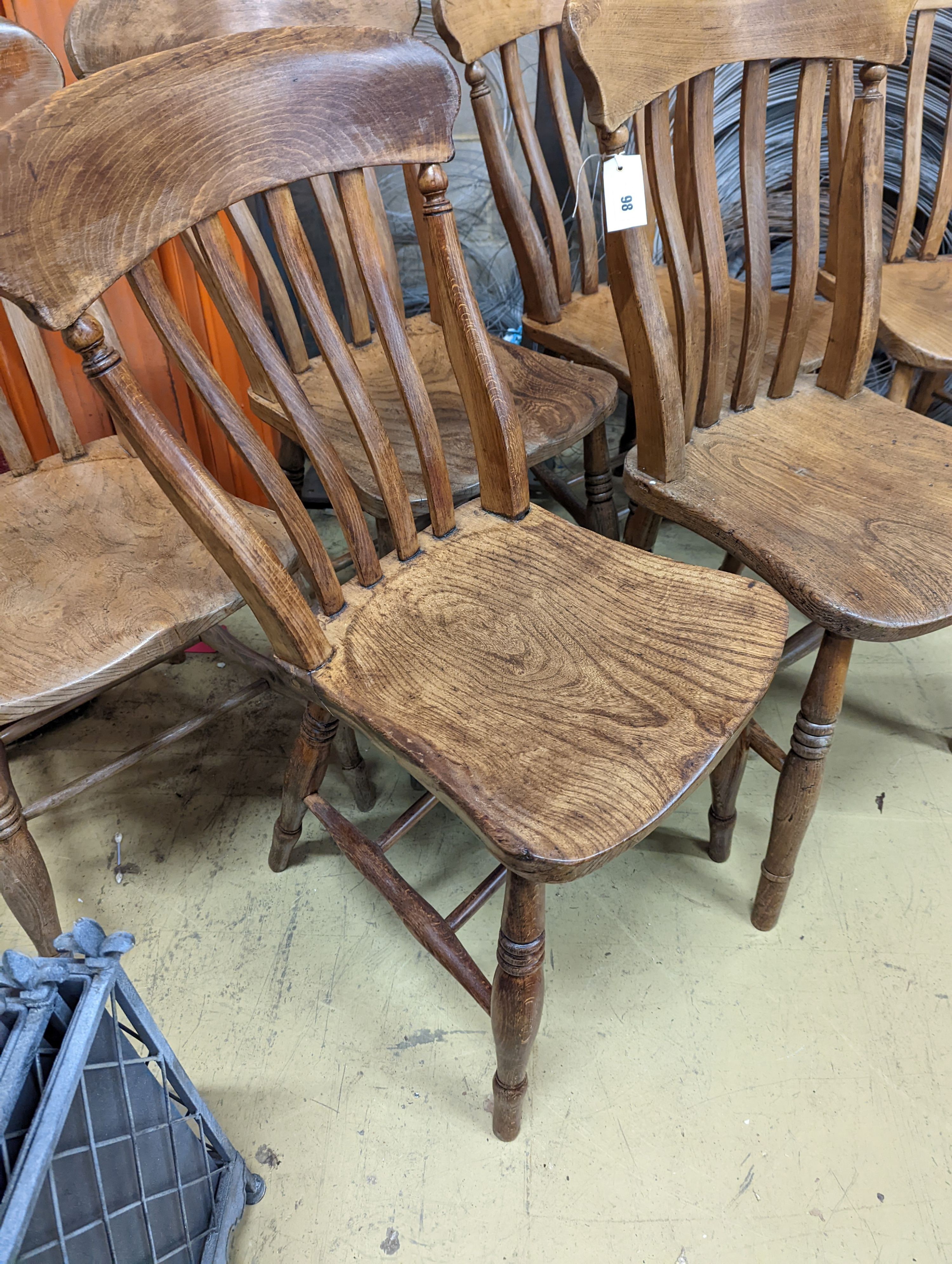 A harlequin set of six Victorian elm and beech Windsor lathe back kitchen chairs